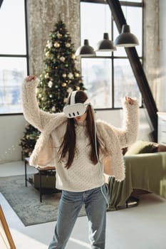 In the ambiance of a Christmas tree, a stunning young woman experiences virtual reality.