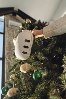 Girl holding a virtual reality headset with a Christmas tree in the background. High quality photo