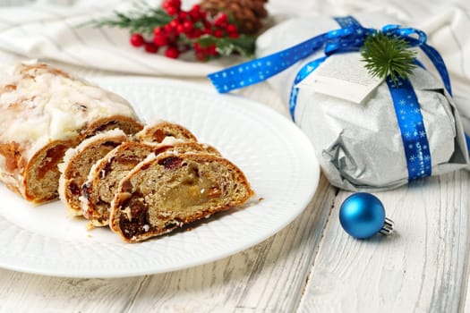 Christmas stollen on plate on white wooden table