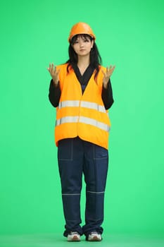 A construction worker on a green background, full-length, she spreads her hands