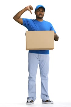 A male deliveryman with a box, on a white background, in full height, points at himself