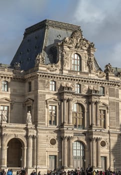 Exterior view of The historical palace building during day time at the Louvre museum.