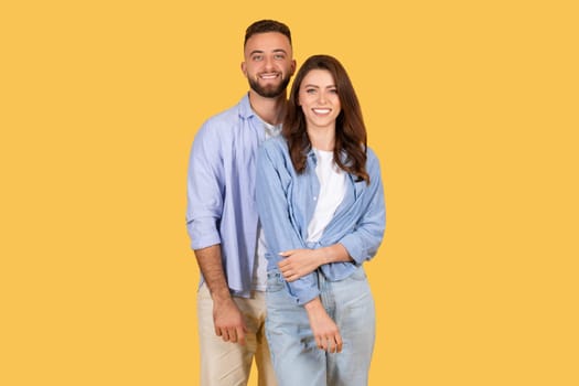 Happy european couple posing together on yellow background