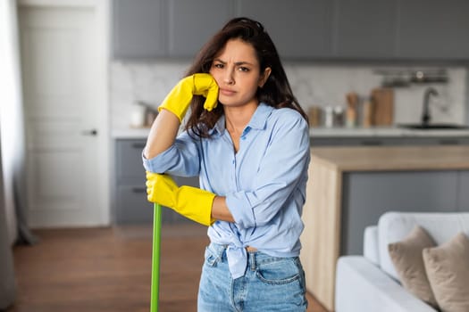 Tired woman with mop taking break from cleaning