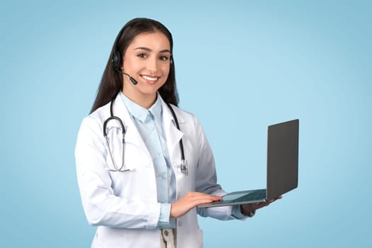 Doctor offering online consultation via laptop, blue background