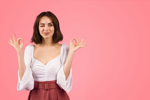 Confident young woman winking and gesturing 'perfect' with her fingers