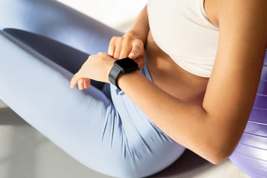 Close-up of a fitness-focused woman checking her smartwatch after a workout