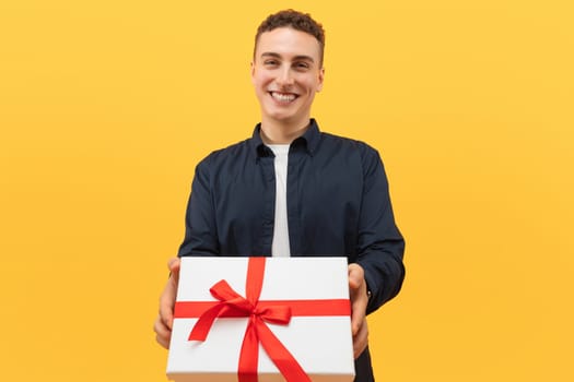 Smiling cool caucasian young man giving present