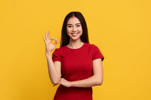 Positive young taiwanese lady showing okay gesture