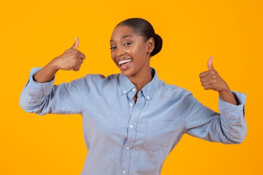 Cheerful Black Woman In Casual Gesturing Thumbs Up In Studio