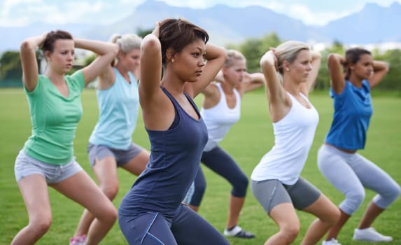 Women, stretching and squats for exercise outdoor, team and ready for workout with health and wellness. Training together on sports field, young athlete group warm up and fitness in the park
