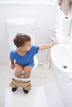 Boy child, potty training and toilet paper with sitting, diaper and thinking for learning, development or progress. Kid, family home and back in bathroom with tissue, hygiene or solution with nappy