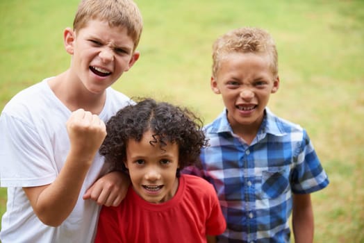 Boys, friends and portrait or happy on grass in summer with confidence, pride or diversity in nature. Kids, face and smile outdoor with play for friendship, care and support on playground or field