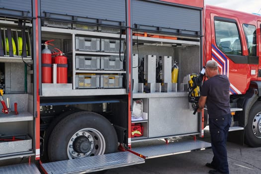 A dedicated firefighter preparing a modern firetruck for deployment to hazardous fire-stricken areas, demonstrating readiness and commitment to emergency response