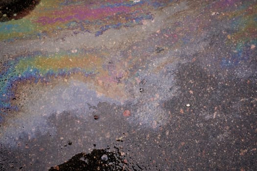 Gasoline oil spill on the pavement as a texture or background.