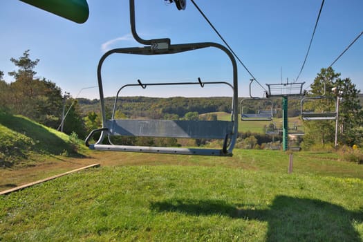 Chairlifts at ski resort in fall with no snow and lots of grass