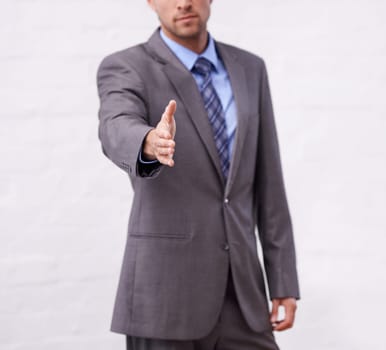 Business man, handshake and introduction for interview, agreement or welcome to deal, success and thank you. Professional or corporate person shaking hands for partnership on a white wall background