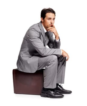 Stress, thinking and business man with briefcase in studio for travel, fail or mistake on white background. Doubt, anxiety and person sitting on a bag with headache, disaster or compliance problem