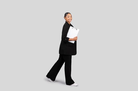 Professionally dressed African American businesswoman walking with confidence