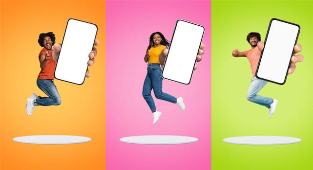 Three Cheerful People Jumping With Big Blank Smartphone And Pointing At Camera