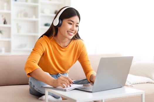 Smiling young asian woman studying from home