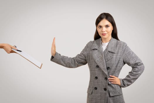 Resolute woman refusing document with hand up