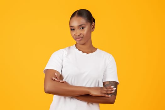 displeased black woman crossing hands over yellow studio background