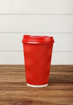 Red paper coffee cup over white wall