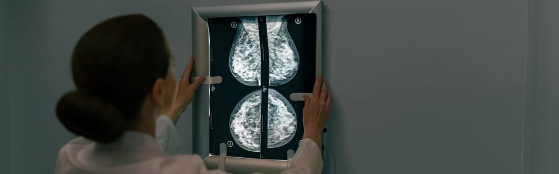 Back view of professional doctor radiologist looking on scan MRI images in medical center