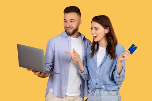 Excited couple with laptop and credit card ready to shop online