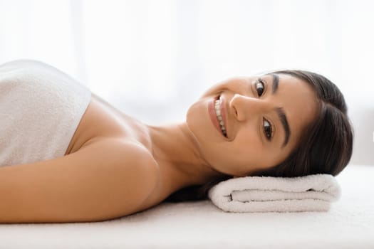 Closeup happy young indian woman relaxing after healing body massage