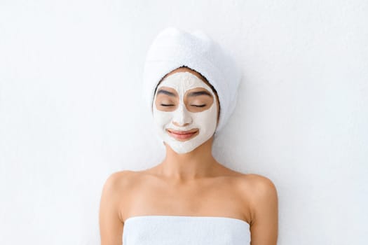 Top view indian woman applying facial clay mask at spa