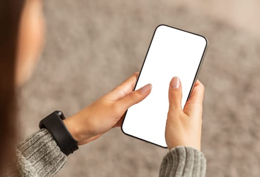 Unrecognizable young lady using smartphone with white screen