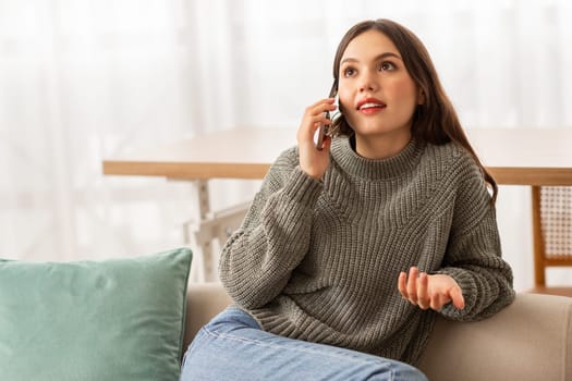 Cheerful pretty young woman have phone conversation at home