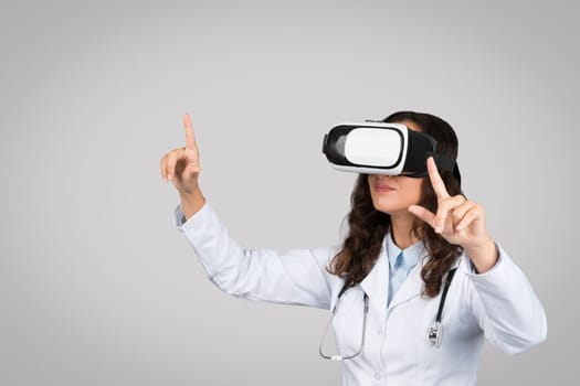 Device for medical education. Female doctor in coat with stethoscope experiencing virtual reality in vr glasses