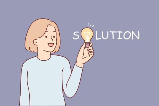 Woman who came up with solution holds light bulb in hand, symbolizing new idea to energy efficiency