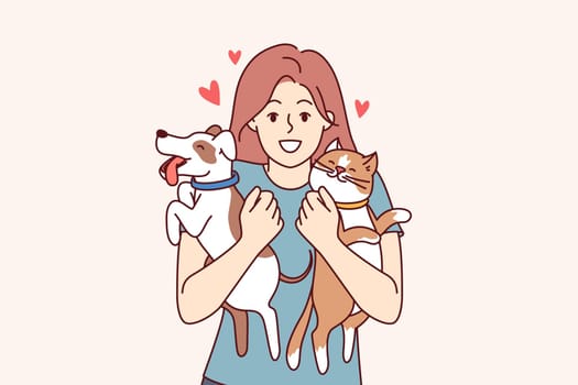 Two pets in hands of teenage girl hugging cat and dog, and feeling love for domesticated animals