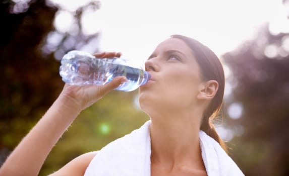 Nature, fitness or woman drinking water for running outside with a towel in exercise for resting break. Training, runner or outdoor workout with liquid, person or female athlete in park for energy