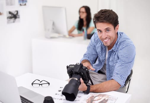 Camera, portrait and photographer looking at photoshoot in a studio or workshop for production. Creative, smile and artist with dslr equipment for photography picture inspection in modern workplace.