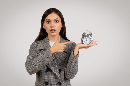Businesswoman with clock, emphasizing time management