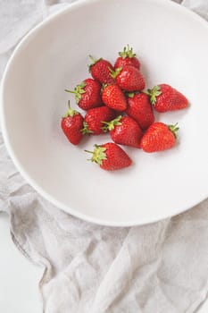 Juicy, tasty, ripe strawberries on a plate, top view. Place for inscription