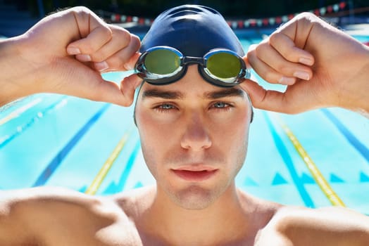 Man, pool and face portrait with goggles, cap or sport with swimming exercise for wellness, health or fitness. Swimmer, athlete or person by water for race, contest and closeup at summer games