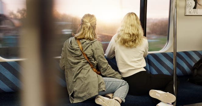 Women, back view and train window with travel, journey with commute or tourism, transportation and sightseeing. Friends are together, traveller and adventure with trip, public transport and metro.
