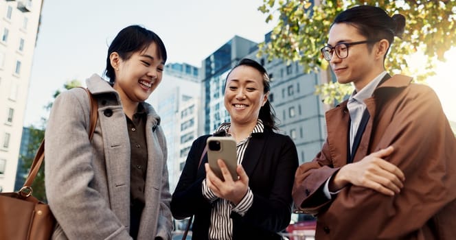 Phone, smile and Japanese business people in city for travel, communication or networking together. Collaboration, internet or email with happy employee group outdoor for commute in Tokyo town