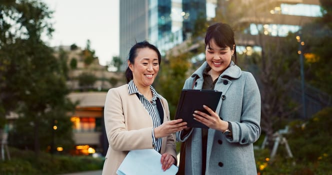 Tablet, conversation and business women in the city talking for communication or bonding. Smile, discussion and professional Asian female people speaking with digital technology together in town