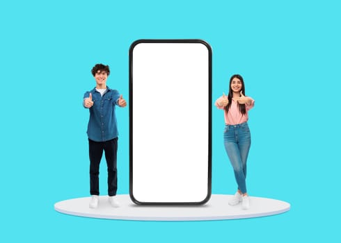 Young couple giving thumbs up near blank phone screen