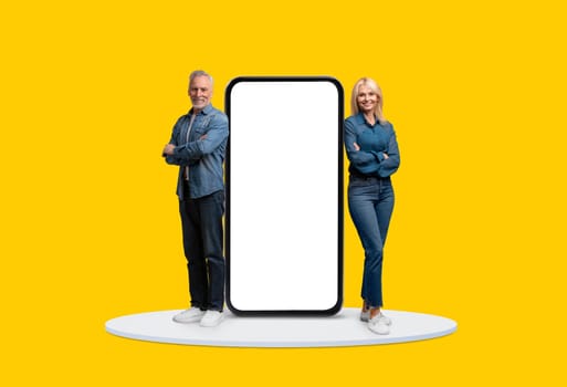 Mature adults with giant smartphone screen, yellow background