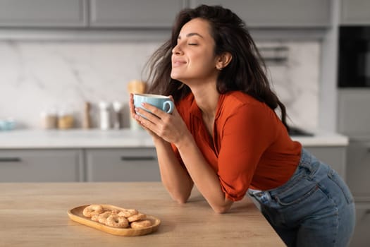 Content young woman savoring coffee at home