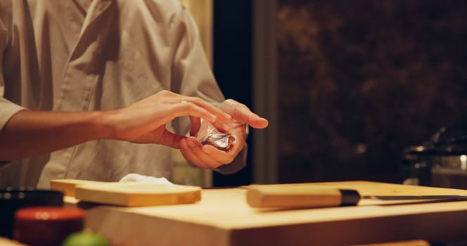 Hands, recipe and chef cooking sushi in restaurant for traditional Japanese cuisine or dish closeup. Kitchen, ingredients for seafood preparation and person working with gourmet food or meal on table.