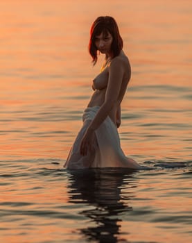 Young naked woman enjoying nature on the seashore